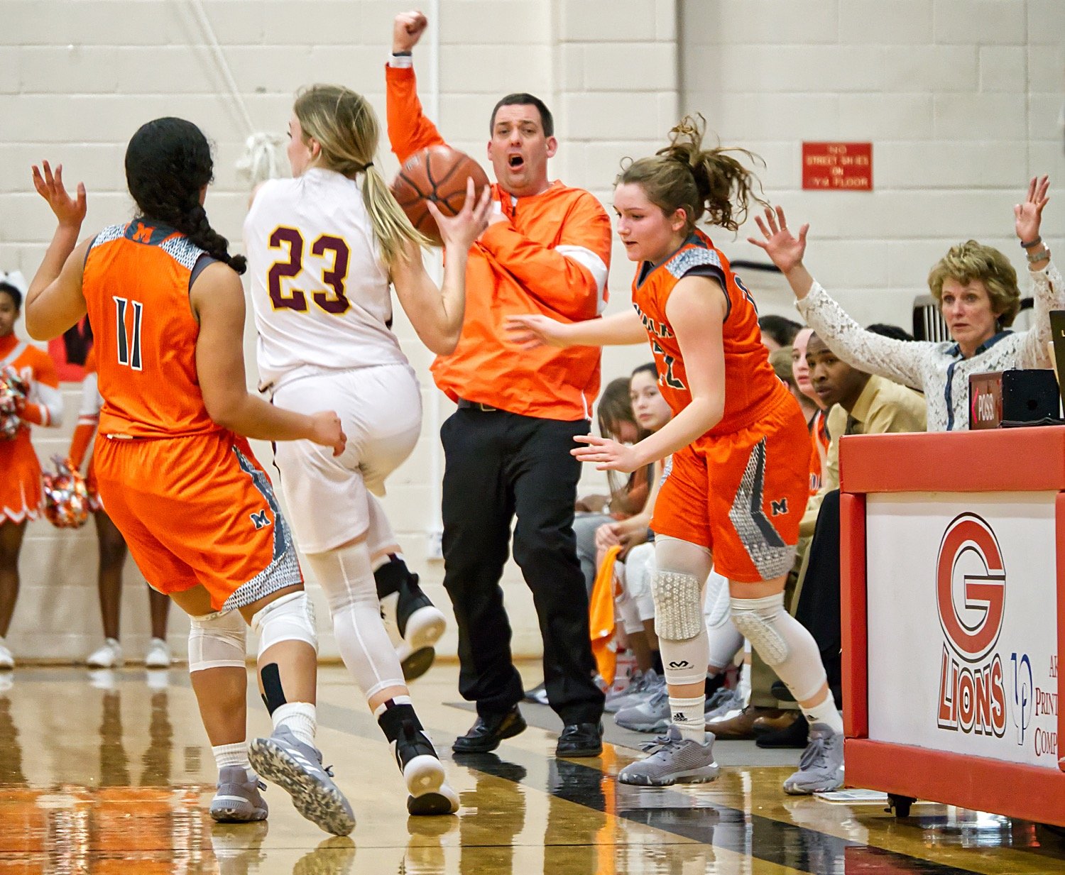 Jaiden Gardner, 11, and Cyndi Butler, 22, put on the trap for Mineola against Bells as Coach Brad Gibson directs traffic. (Monitor photo by Sam Major)